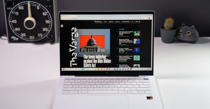 A white HP OmniBook X laptop sitting on a white tabletop in front of desk accessories.