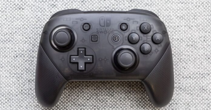 A Nintendo Switch Pro controller on a textured surface.